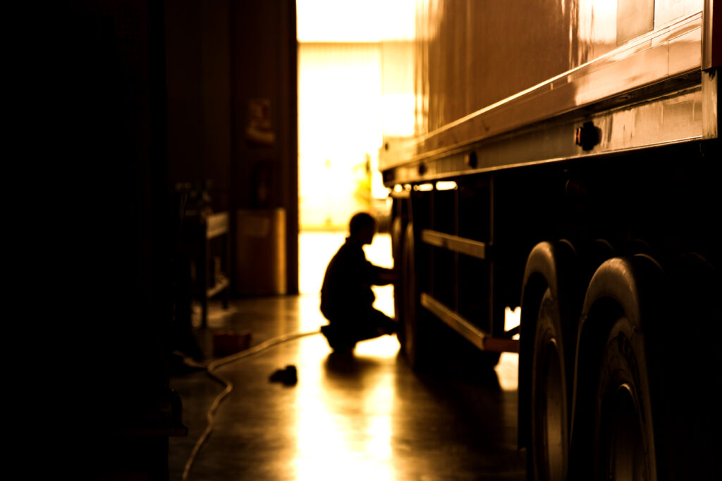 silhouette,blur,automobile,mechanic,checking,truck,in,the,garage,,selective